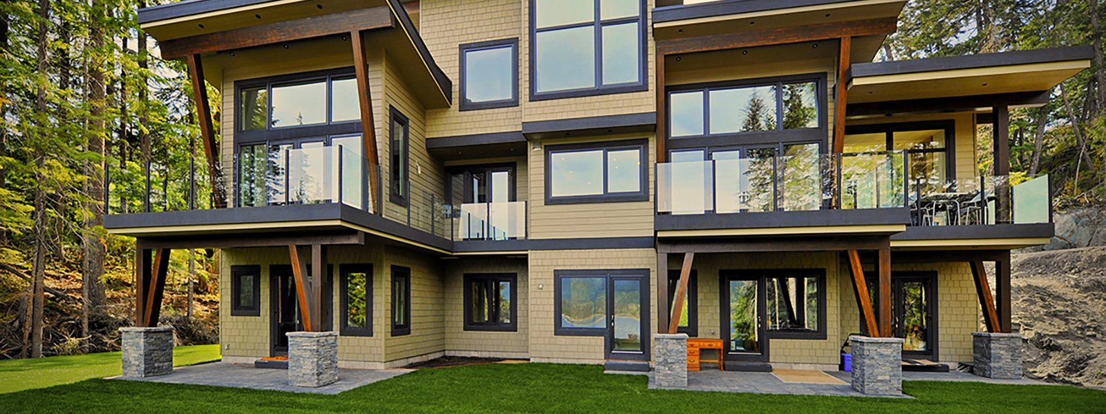 Casa de tres pisos con azulejos amarillos independiente con jardín y arboles al fondo con ventanas de pvc gris oscuro