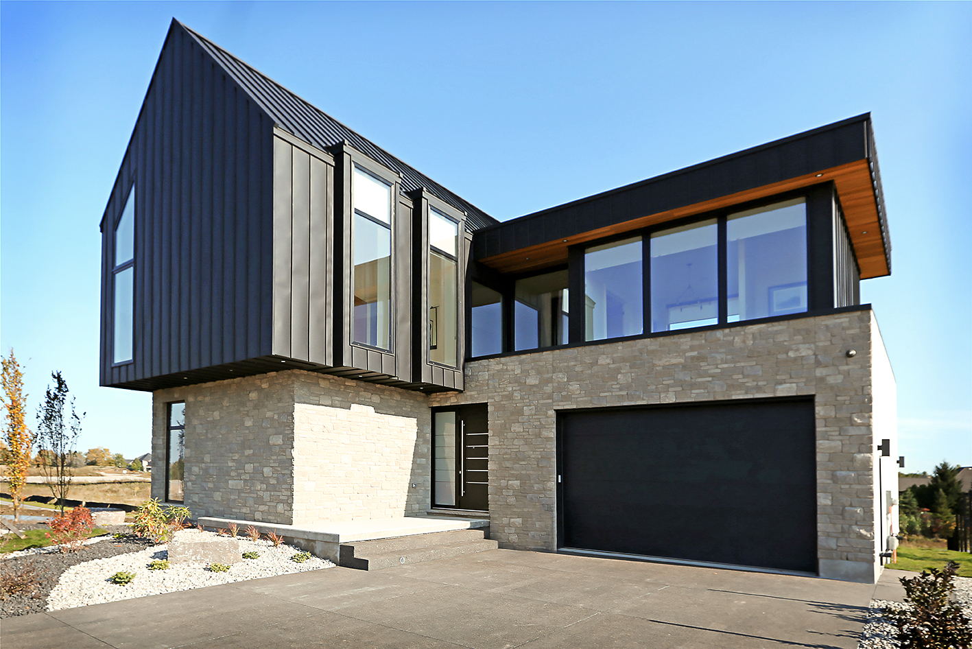 Casa independiente de dos pisos con la parte baja de piedra y la superior de chapa con grandes ventanas de pvc 