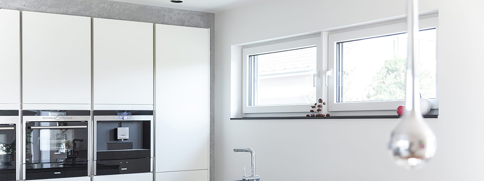 Cocina blanca con isla central y ventanas Kömerling76 AD Xtrem