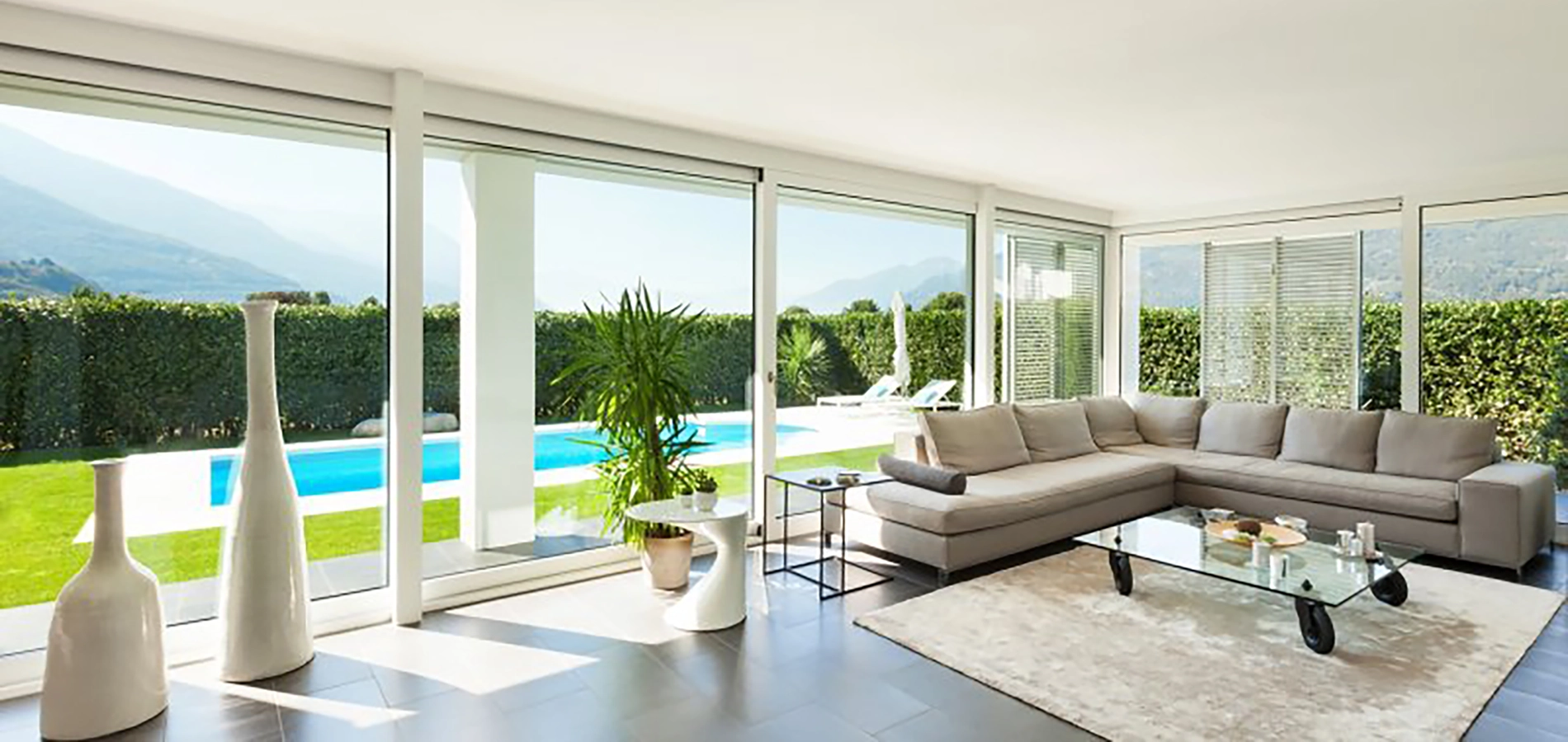 Salon con grandes ventanales que miran a una piscina